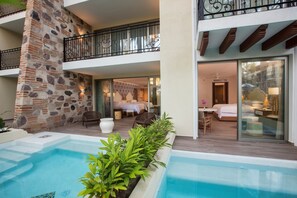 Un hotel con piscina, mobiliario exterior y balcón.