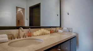 A bathroom with two sinks, a large mirror, and a towel rack.