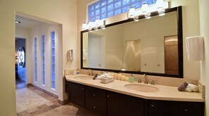 A modern hotel bathroom with a large mirror, two sinks, and a vanity with cabinets. - Villa Vegas by Cabo Platinum (Cabo San Lucas)