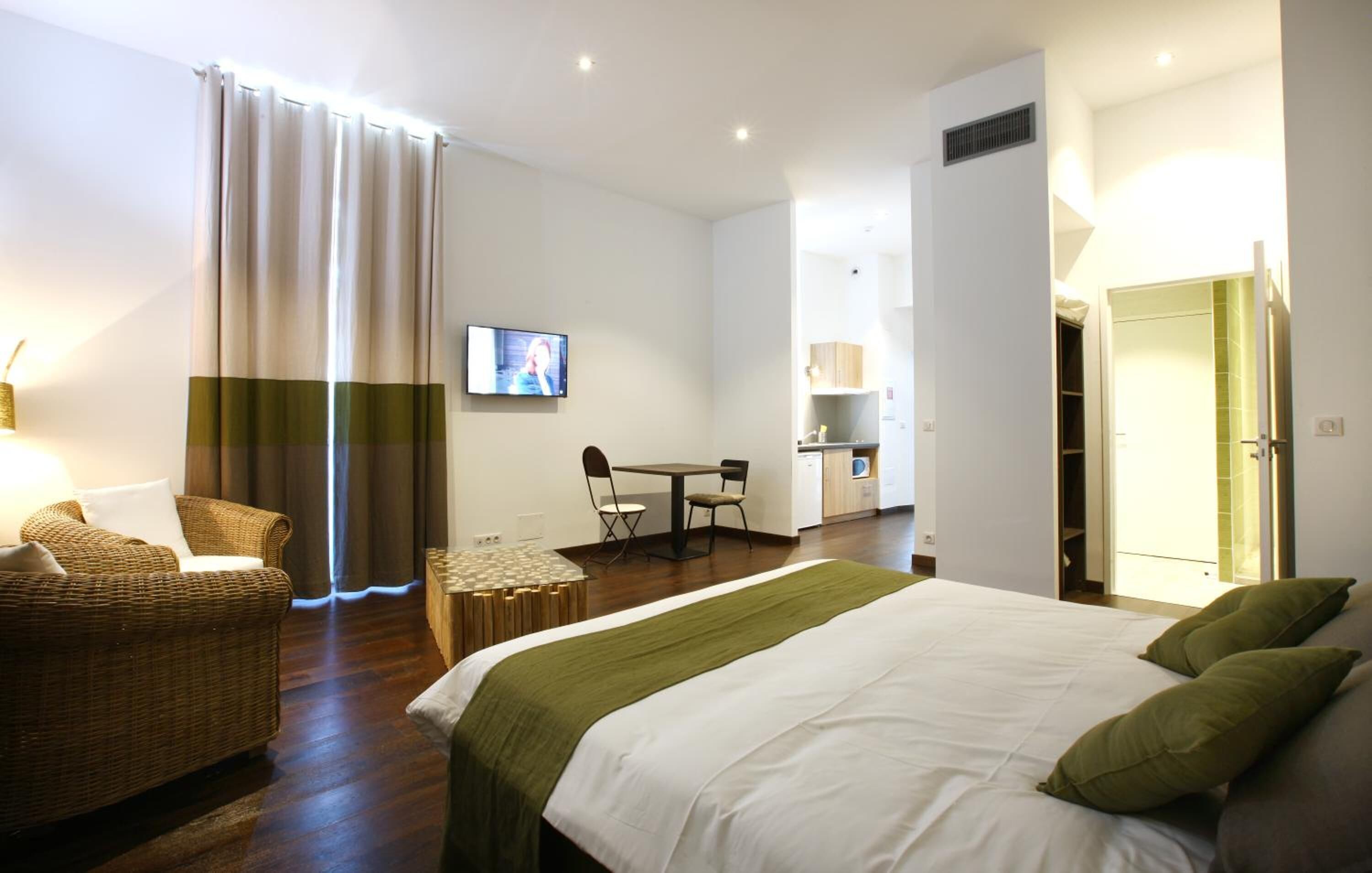 Une chambre d’hôtel avec un lit, une chaise, une table et un téléviseur.