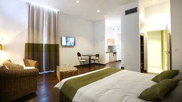 Una habitación de hotel con una cama, una silla, una mesa y un televisor.