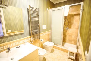 Un baño con lavamanos, inodoro y ducha.