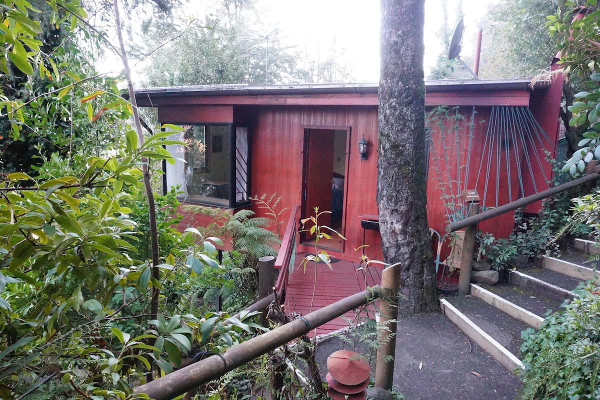 Ein rotes Holzgebäude mit einer Treppe, die zu einer Tür führt.