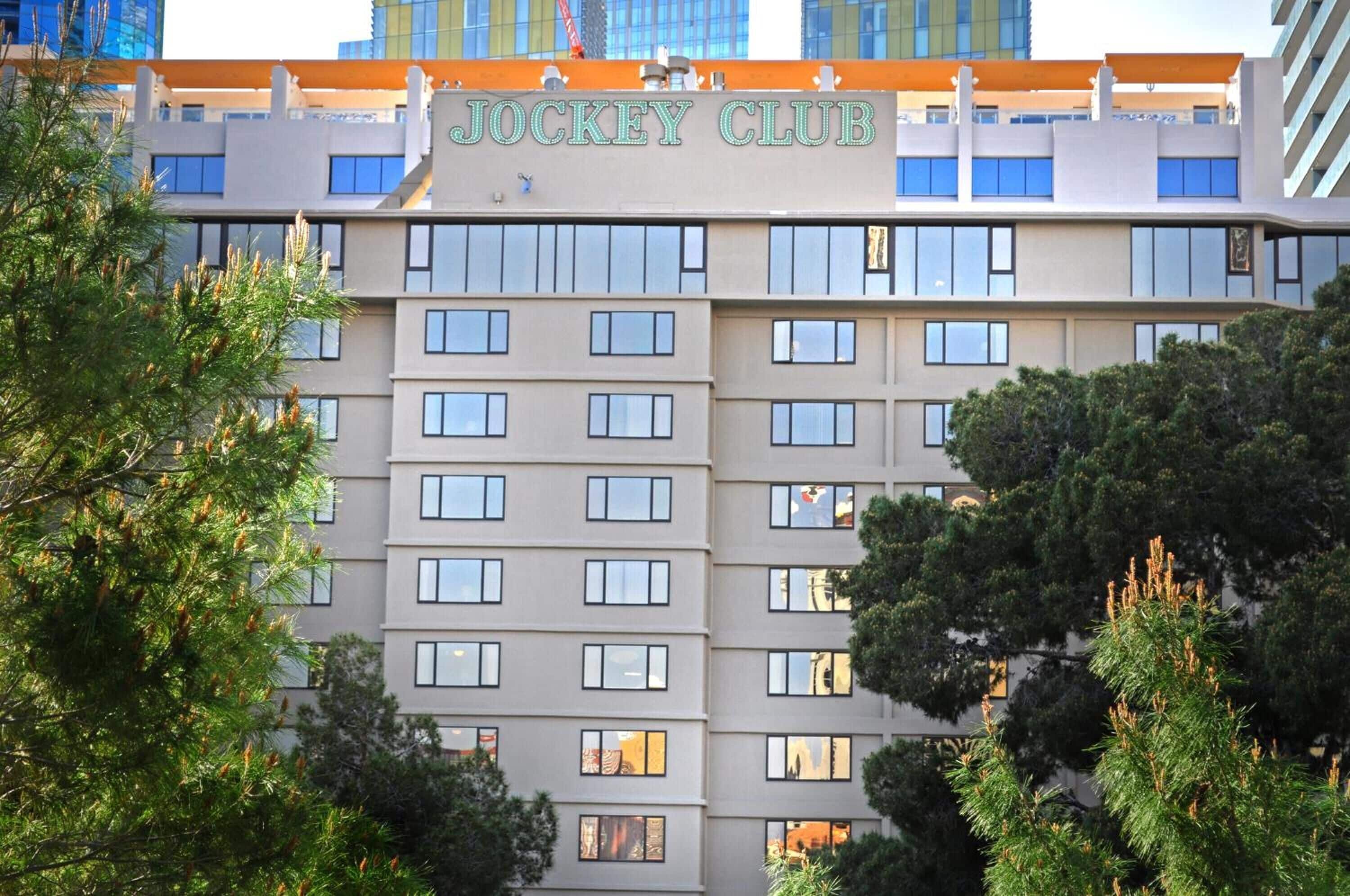 A multi-story building with a sign reading "Jockey Club" at the top.