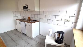 Apartemen Comfort, 3 kamar tidur, pemandangan kebun (08) | Dapur kecil pribadi | Lemari es, microwave, kompor, dan mesin pembuat kopi/teh