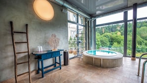 Un intérieur moderne avec une échelle en bois, une table bleue et un jacuzzi.