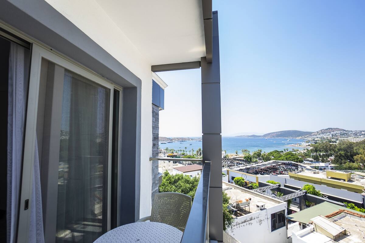 A balcony with a view of the sea and buildings.