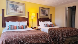A hotel room with two beds, each with a patterned bedspread, a nightstand with a lamp, and framed artwork on the walls. - Hampton Inn (not a Hilton Affiliate) Camp Hill - Harrisburg SW (Camp Hill)