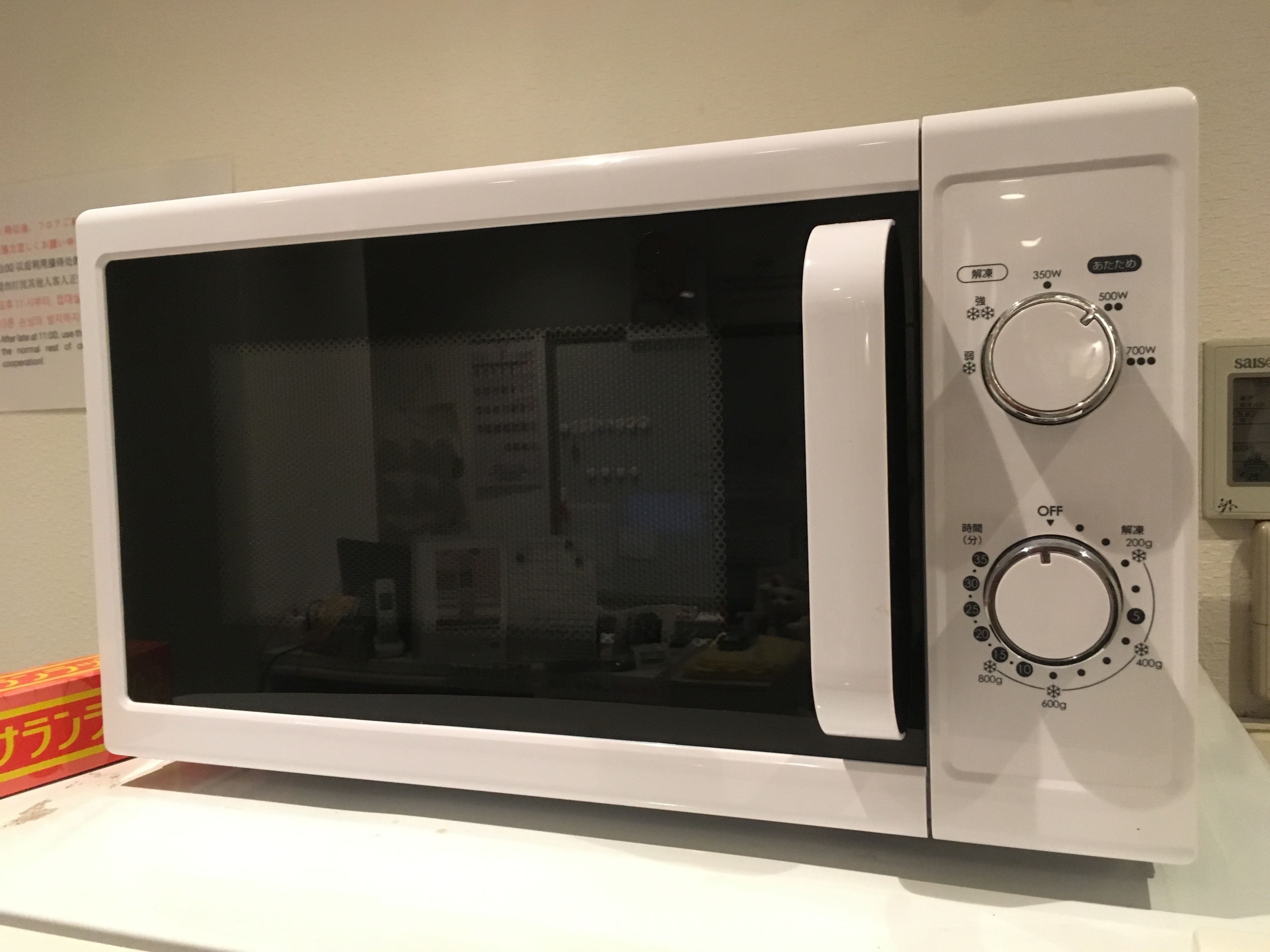 A white microwave oven with two control knobs and a digital display.