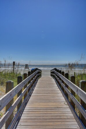 A wooden boardwalk leading to a beach with a clear sky. - Tropical Paradise!! New Summer Discounts!!! (North Myrtle Beach)