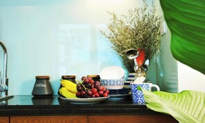 A kitchen counter with a coffee pot, bananas, grapes, and a blue and white patterned dish set. - quiet, spacious and comfortable apartment close to Hanoi Old Quarter (Dong Da)