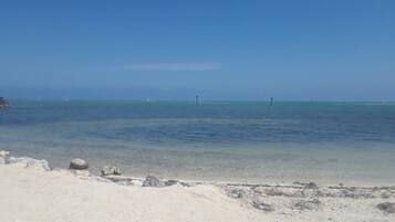 Pantai persendirian, pasir putih, kerusi lepak pantai, tuala pantai