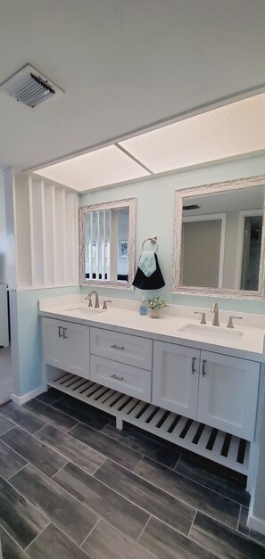 A modern bathroom with a large vanity, two sinks, and a mirror. - 306 SEASCAPE CONDOMINIUMS BEACH SIDE CONDO (South Padre Island)