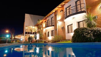 Una piscina al aire libre, sillones reclinables de piscina