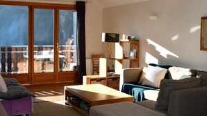 Una sala de estar moderna con un sofá, una mesa de centro y un comedor con una mesa y sillas.