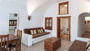 Une pièce avec un canapé blanc, une table en bois, une commode en bois et un miroir au mur.