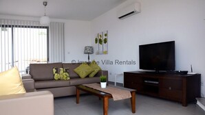 A modern living room with a sofa, coffee table, TV, and a cabinet.