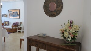 A room with a wooden desk, a vase of flowers, and a wall-mounted artwork. -  Wonderful view of the beach and river,  front line with garage T2. 1978 / AL (Praia da Rocha Portimão)