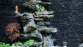 Una cascada de rocas con estatuas y plantas.