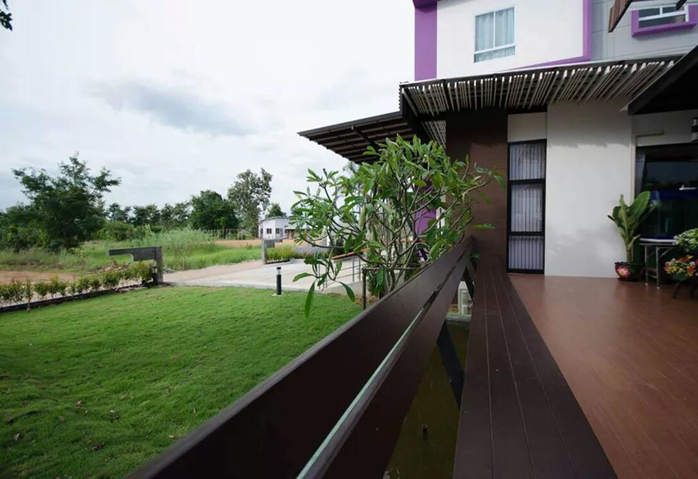 Una casa moderna con terraza de madera y un pequeño estanque.