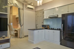Une cuisine moderne avec des meubles blancs, un réfrigérateur en acier inoxydable, un four à micro-ondes et une cuisinière à gaz.