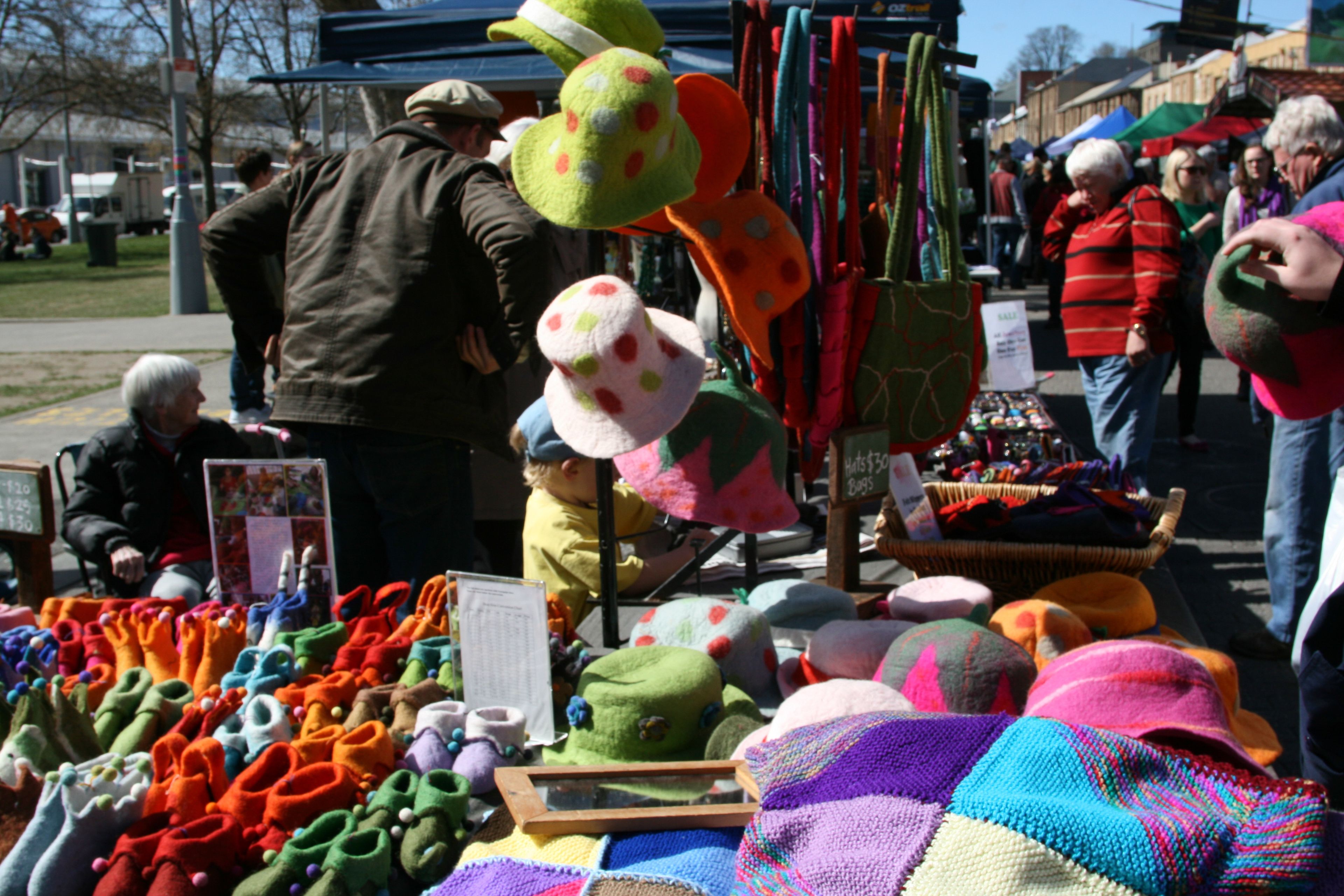 Ein Marktstand mit verschiedenen bunten Hüten und Accessoires.