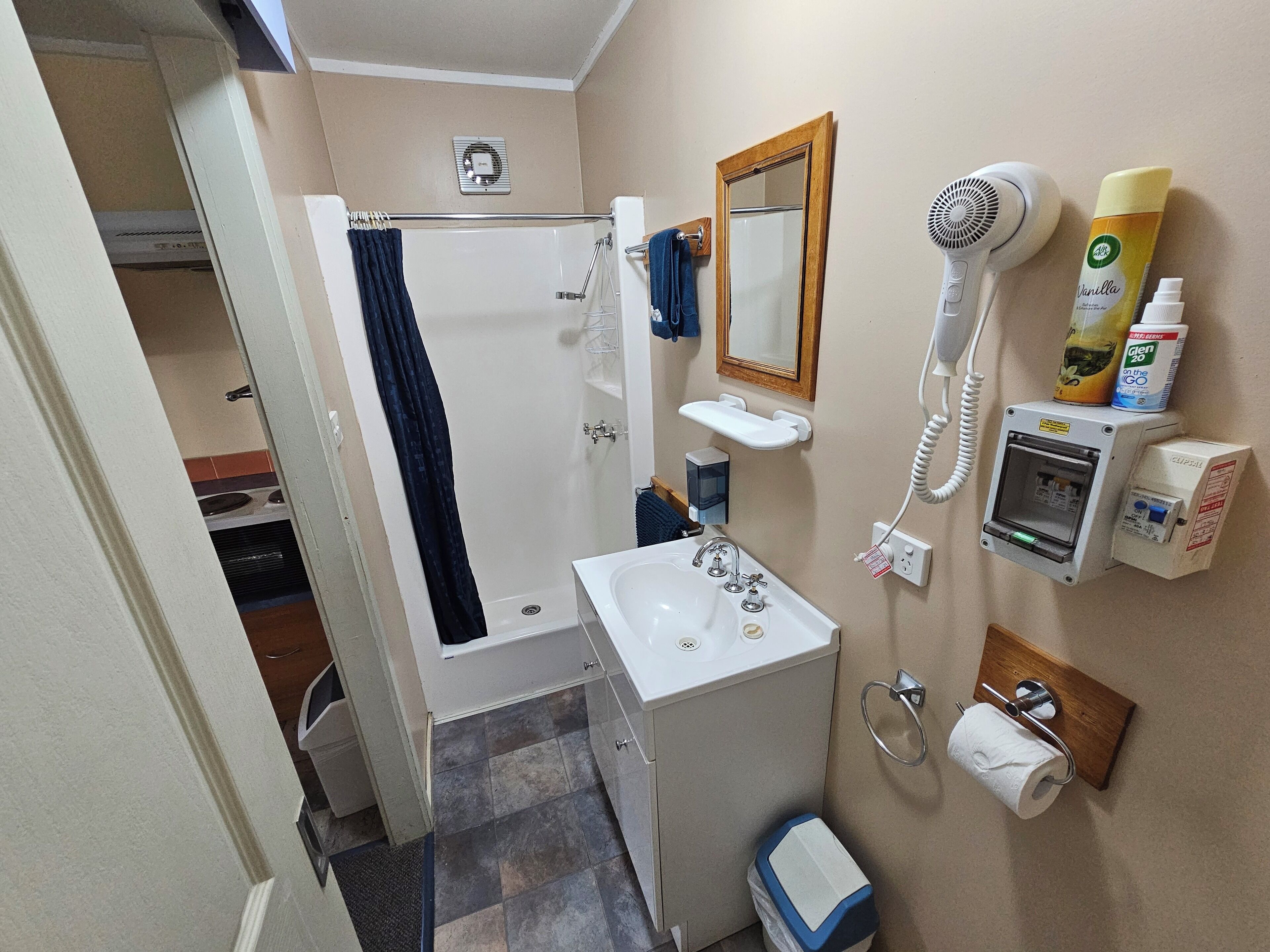 A bathroom with a shower, sink, and a hairdryer.