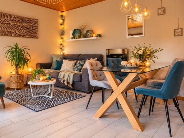 Una sala de estar moderna con un sofá, una mesa de centro de vidrio y una mesa de comedor con sillas.