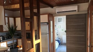 A compact kitchen with a refrigerator, a microwave, and a stove. There is a potted plant on the counter.