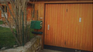 A wooden garage door with a mailbox and a number "5" sign.