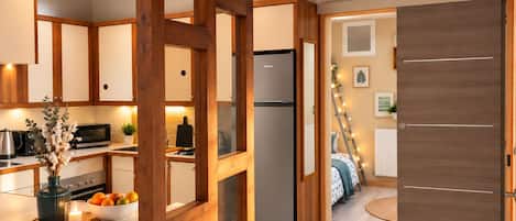 A modern kitchen with wooden beams, a built-in oven, and a refrigerator.