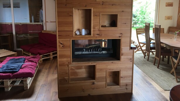 A wooden wall unit with multiple compartments, a dining area with wooden chairs and a table, and a red sofa. - Ideal house for 4 families with 2 children each  (Montgeron)