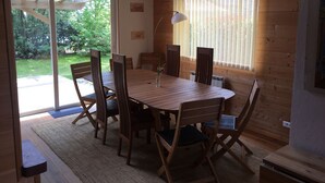 A wooden dining table with six chairs, a lamp, and a window with blinds. - Ideal house for 4 families with 2 children each  (Montgeron)