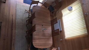 A wooden dining table with chairs, a woven rug, and a window with blinds. - Ideal house for 4 families with 2 children each  (Montgeron)