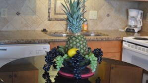 A kitchen with a pineapple centerpiece, a coffee maker, and a dishwasher. - Comfy Direct Oceanfront Condo.  Our Happy Place can be Yours. Book a great deal! (North Myrtle Beach)