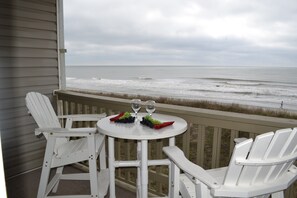 A white table with two chairs on a balcony overlooking the ocean. - Comfy Direct Oceanfront Condo. Our Happy Place can be Yours. Book a great deal! (North Myrtle Beach)