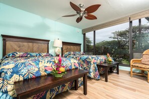 A bedroom with a large bed, a nightstand, a chair, and a ceiling fan. - Mahana Villas | Oceanfront 2 BR | Car Incl. w/ 6+ Nights | MAH-419 by KBM (Lahaina)