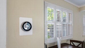 A thermostat set to 75°F, a dining table, and a window with blinds. - Only 1 block to FRONT BEACH! Perfect location in Ocean Springs! The King Suite (Ocean Springs)