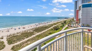 A beach view with a pier, a hotel, and a clear sky. - Scenic Views  Atlantica Resort 🏖️ Ocean Front🏖️ (Myrtle Beach)
