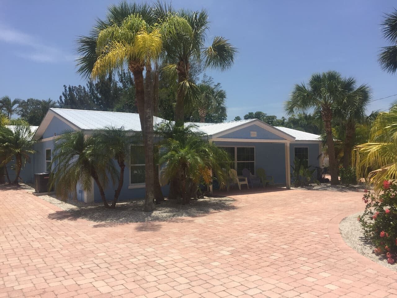 A building with a paved driveway and palm trees.