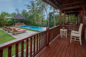 A wooden deck with a pool, lounge chairs, and a gazebo. - Buah Nagasari Cottages by Supala Hospitality (Ubud)