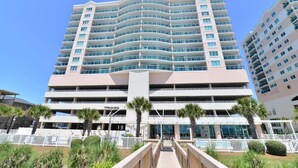 A multi-story hotel with a curved facade, a central entrance, and a parking garage below. - Penthouse Stunning Ocean Views Lazy River Indoor Pool (North Myrtle Beach)