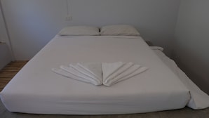 Un llit ben fet amb una tovallola disposada en forma de ventall sobre el llençol.