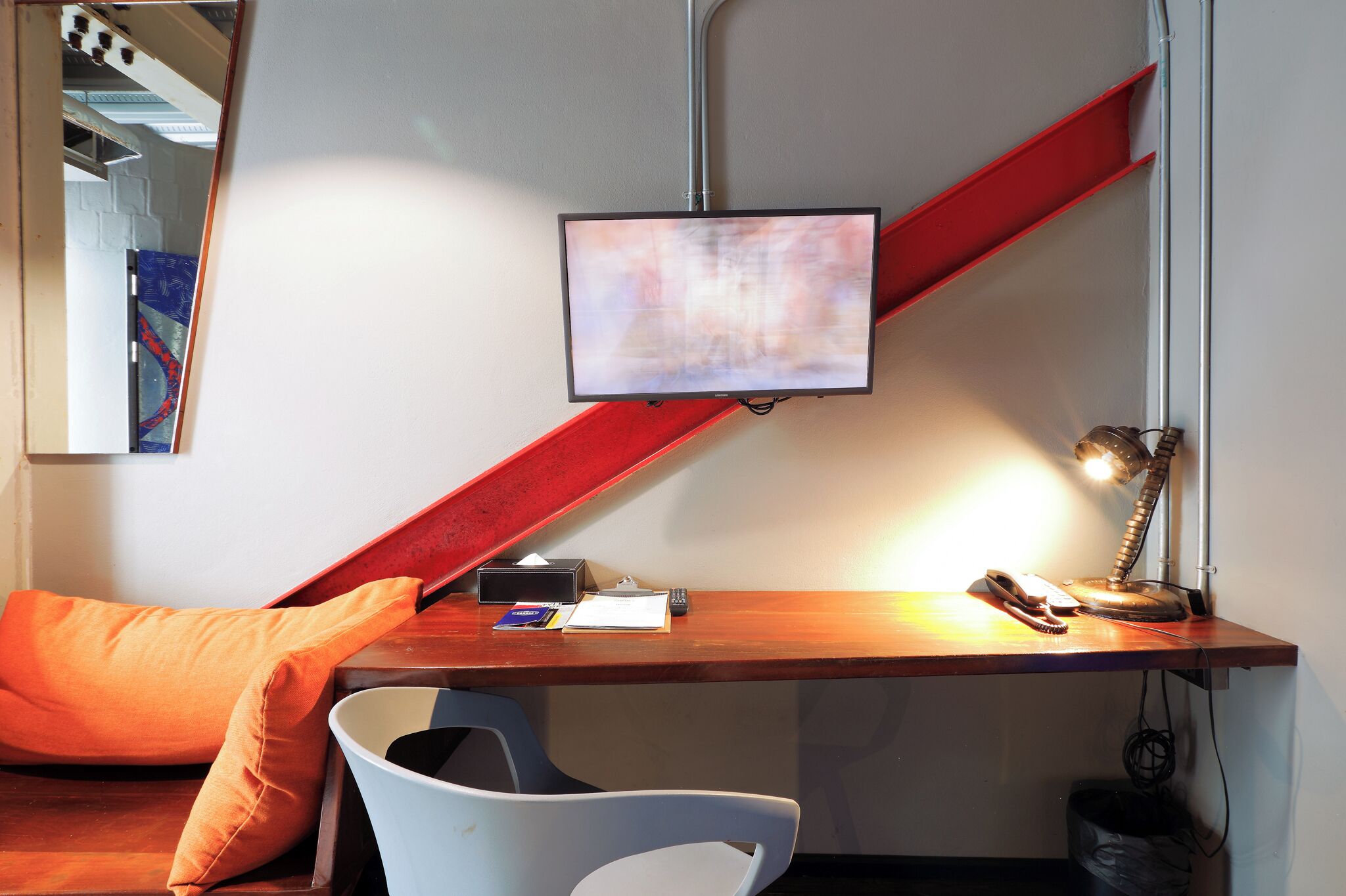 Un espace de bureau moderne comprenant un bureau, une chaise et un grand écran.