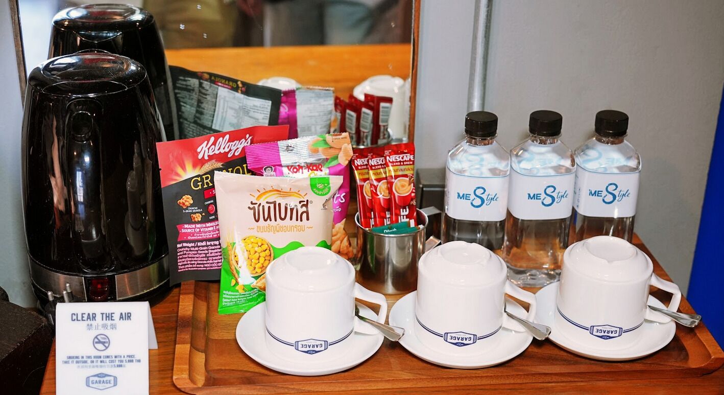 A tray with coffee makers, coffee packets, bottled water, and cups.