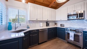 A modern kitchen with white cabinets, a stainless steel range, and a dishwasher. - Beautiful Moonstone Beach Rental Just Steps Away From the Boardwalk! (Cambria)