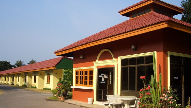 A row of single-story buildings with red-tiled roofs and large windows.