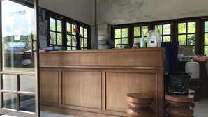 A reception desk with a wooden finish, a glass door entrance, and a view of the outside.