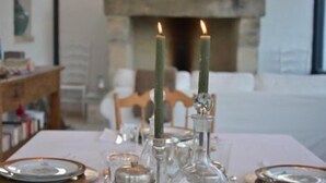 A dining table with candles, glassware, and plates set for a meal. - Masseria Spartivento (Melendugno)
