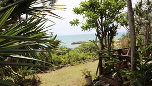 A garden path leading to a beach with various plants and a wooden fence. - Uminosoba Pension (Ginoza)